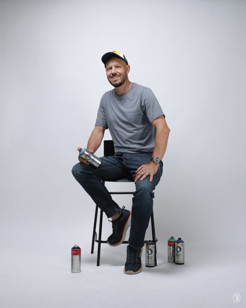 Portrait de l'artiste Kesh avec ses bombes de peinture